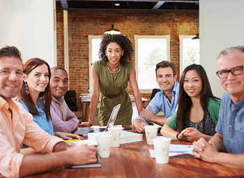 several employees gathered around a table having a meeting